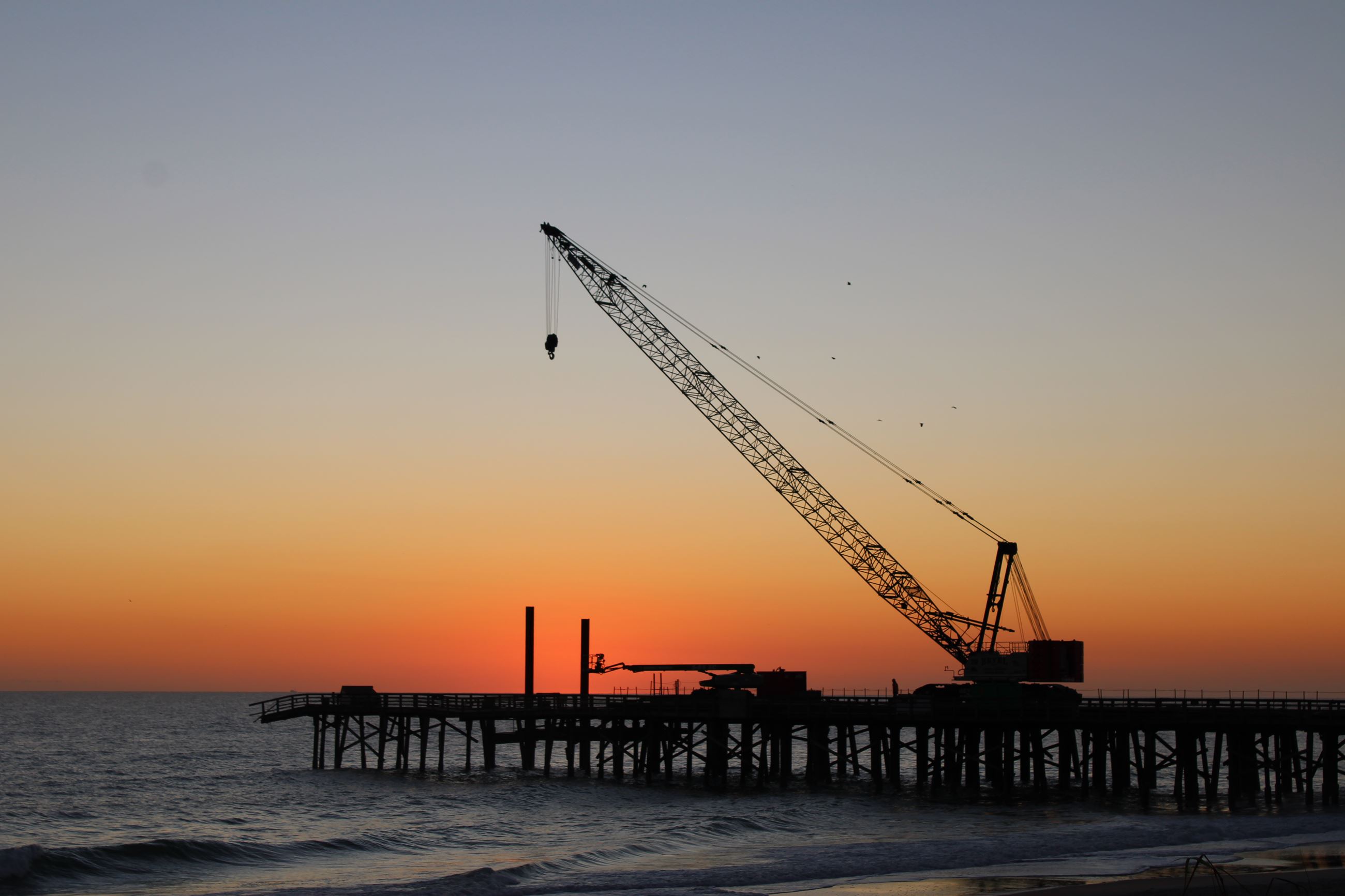 photo of pier crane at sunrise